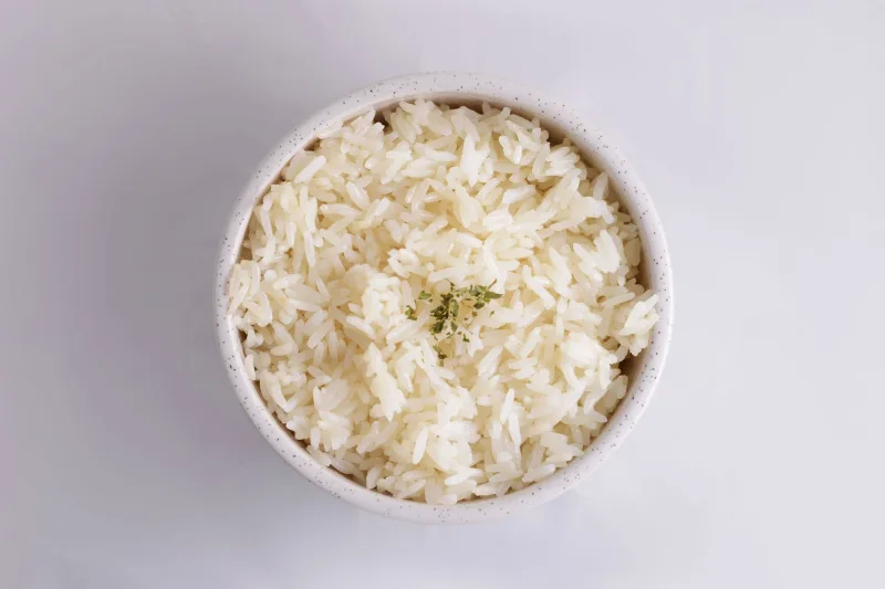 Açık renkli zeminde bir kâse beyaz pirinç pilavı